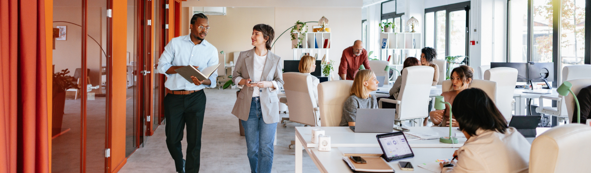 two people walking through a busy finance office